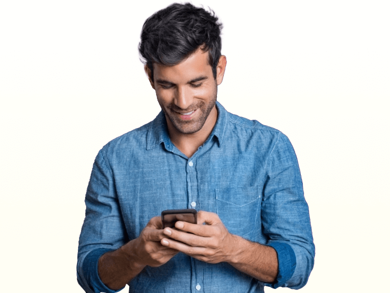 A man smiling while looking at a mobile phone