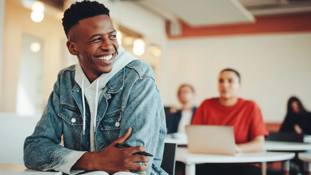 A young man in a classroom.