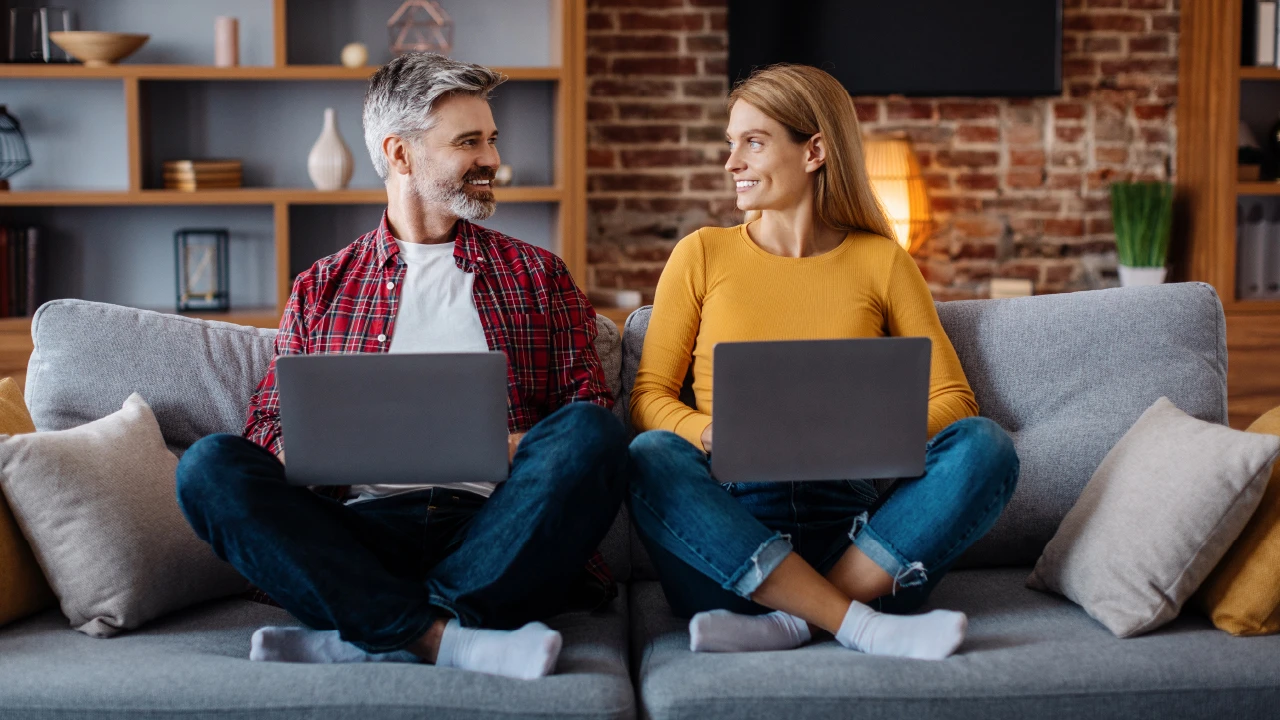 A couple holiday shopping on their laptops.