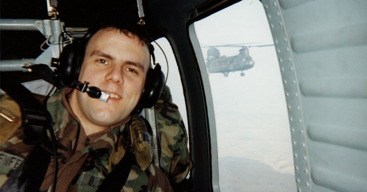 Headshot of John Rosenfeld in U.S. army helicopter
