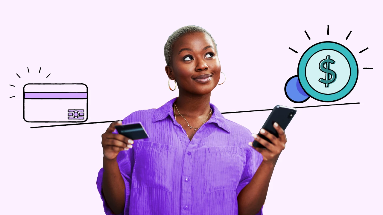 A woman holding a credit card and phone considering her options. 