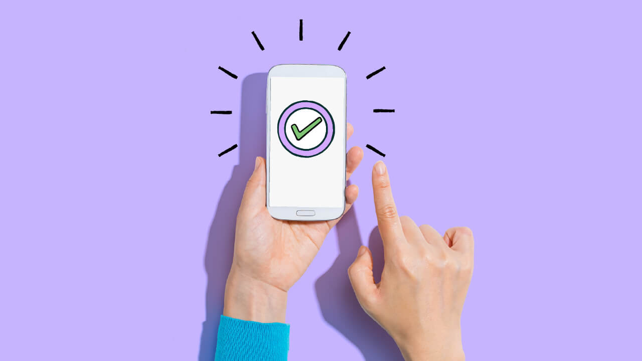 Person holding mobile phone with a check mark indicating success. 