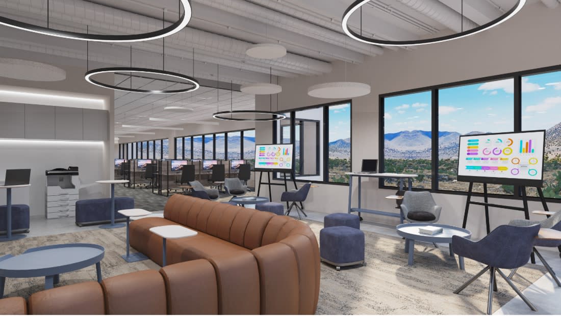 Office space with soft seating, whiteboards, and standing desks. 