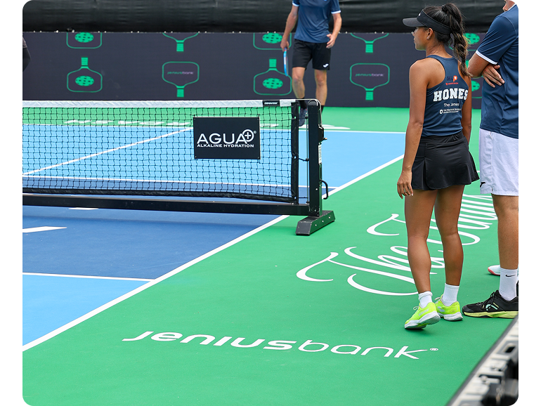 Jenius Bank logo on the pickleball court with players preparing for a match.  