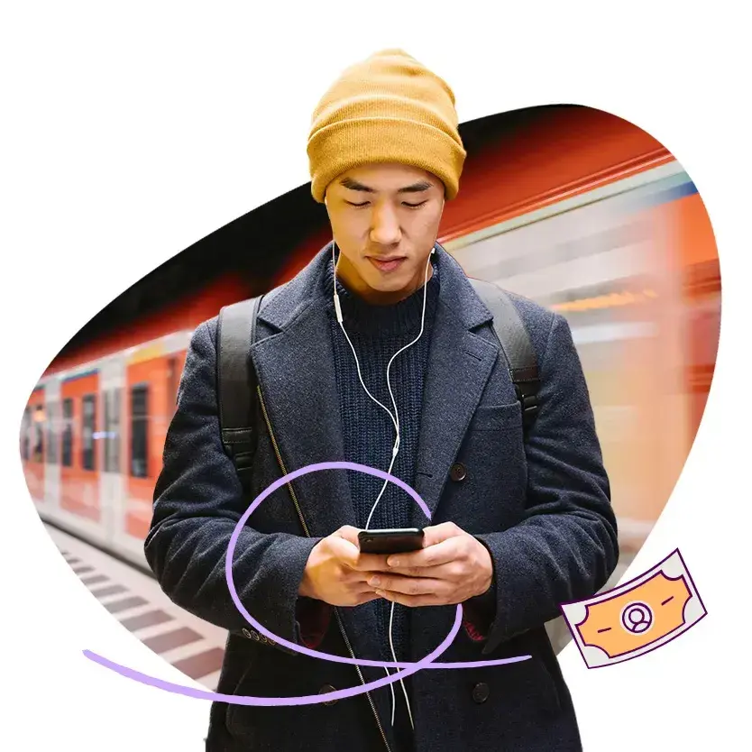 A man banking on his mobile phone at a train station. 