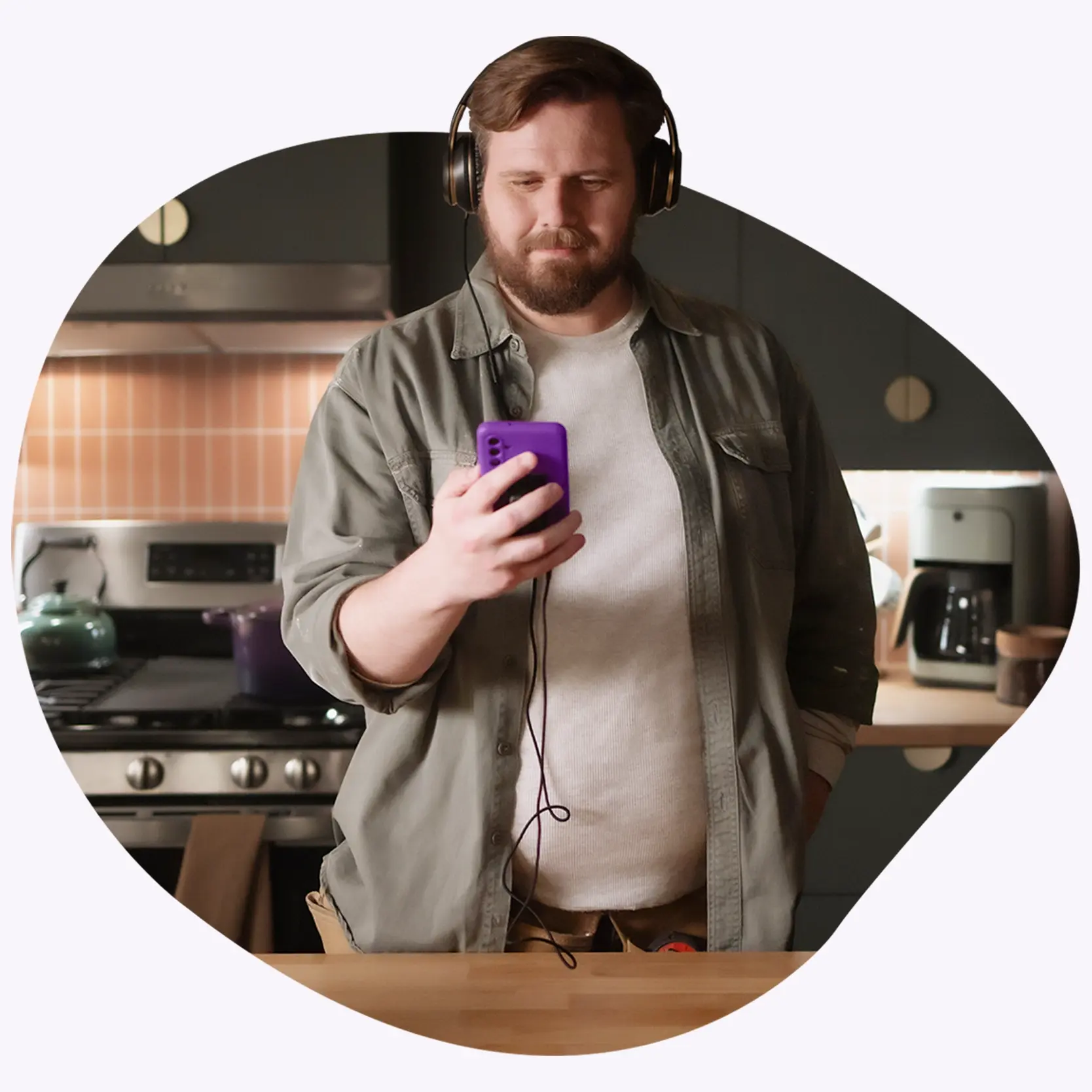 Man standing proudly in a recently renovated kitchen.